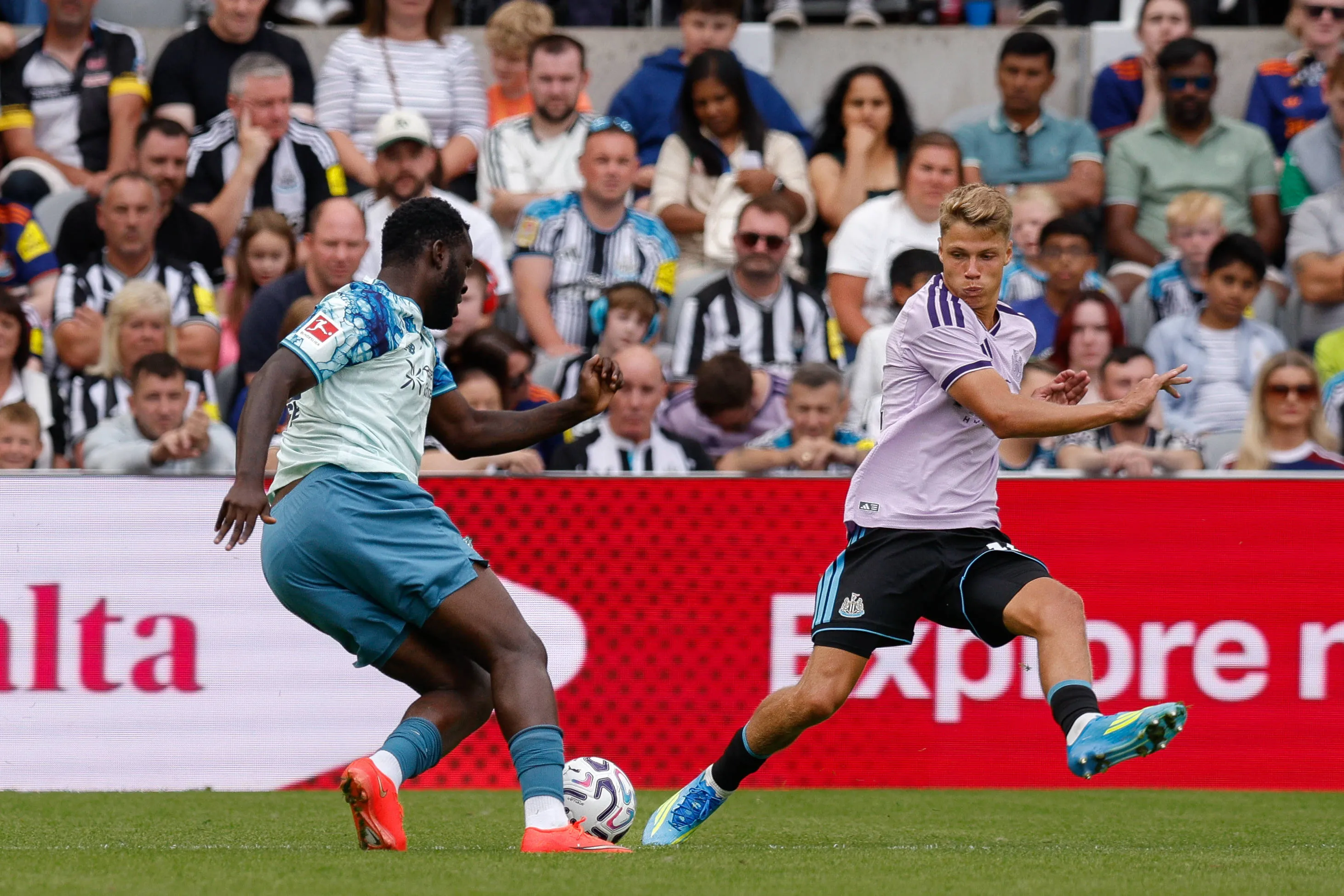 Victor Boniface of Bayer Leverkusen turns Sean Steur of Newcastle United