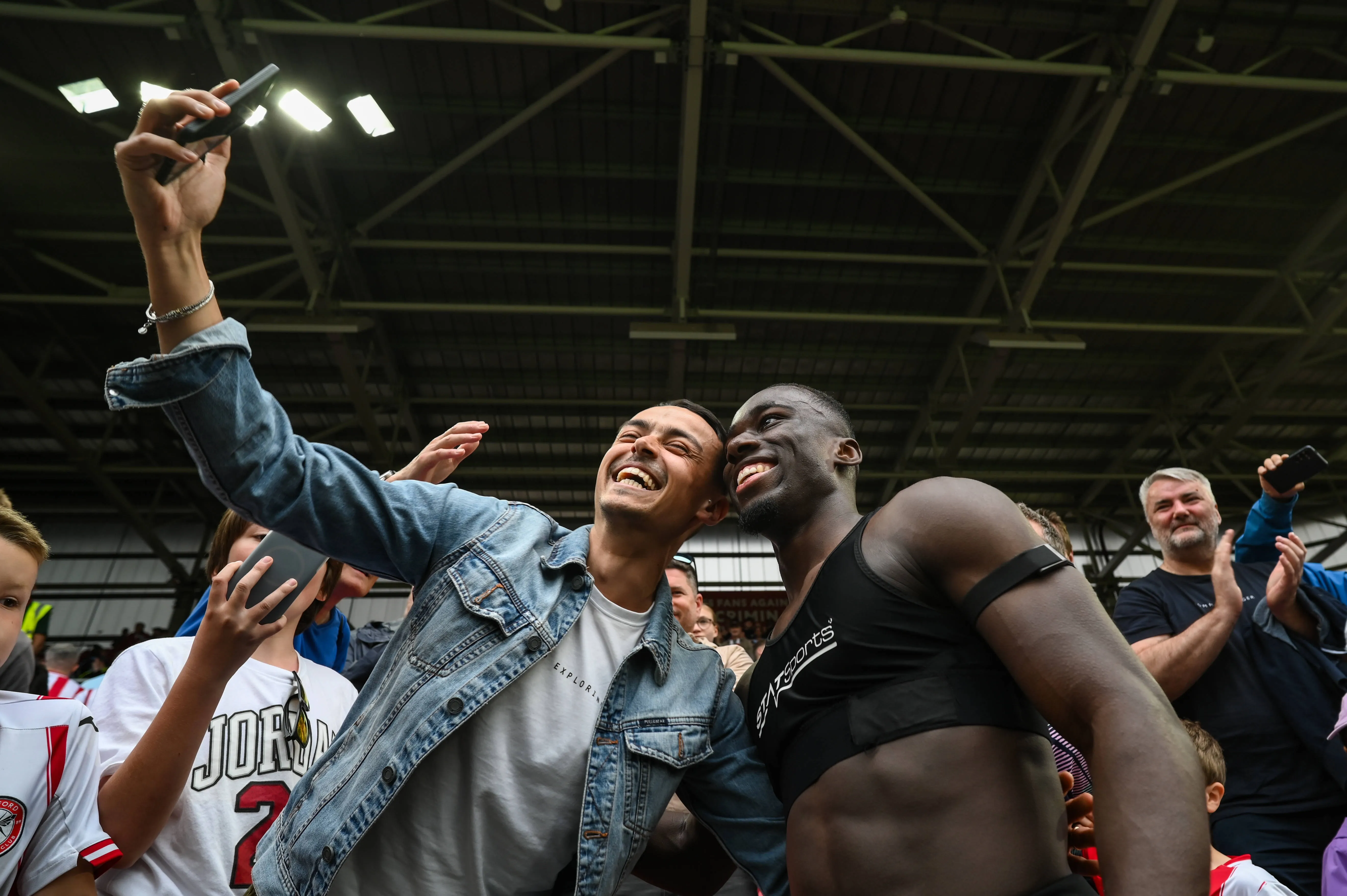 Michael Kayode of Brentford takes a selfie with a fan