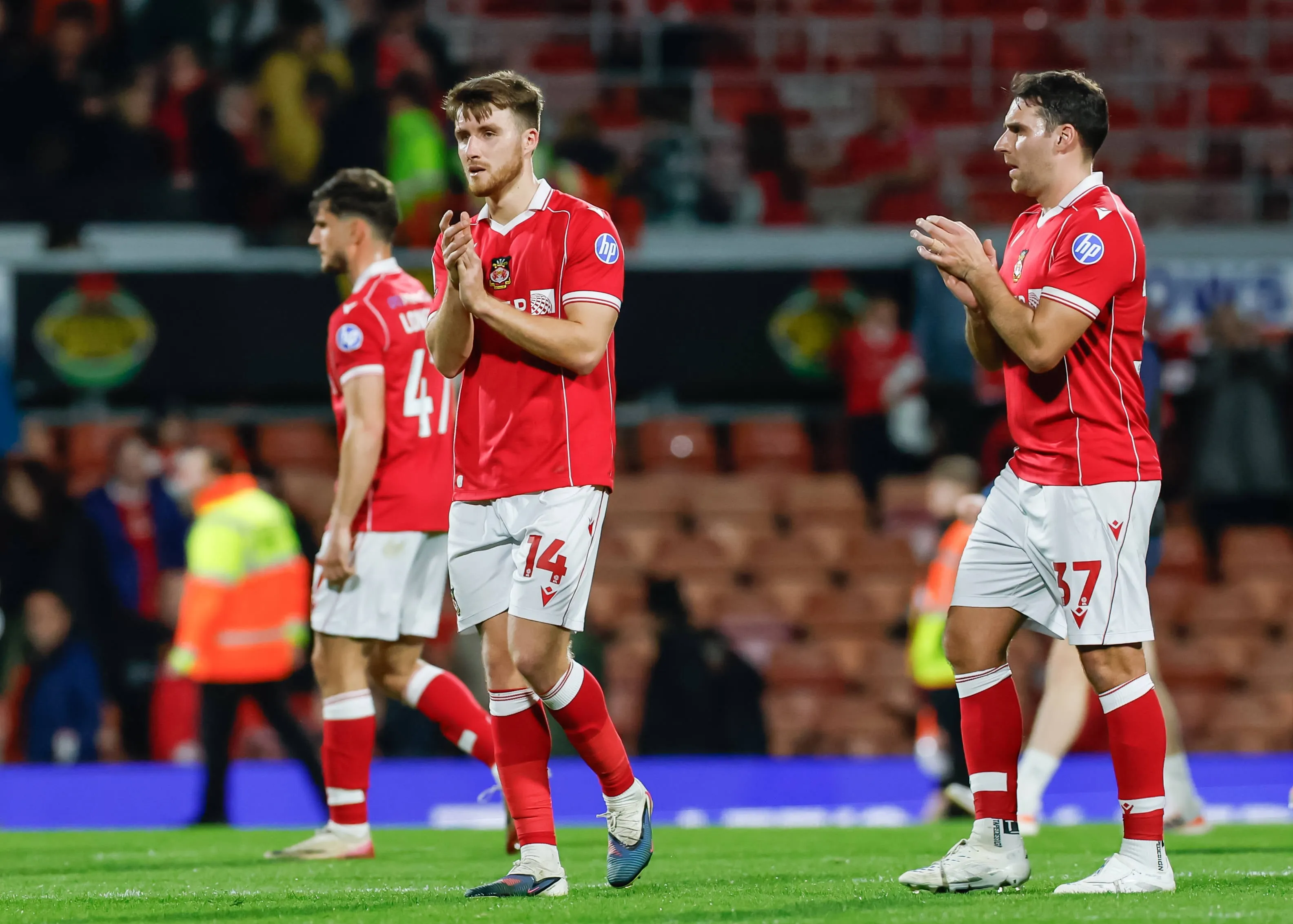 George Thomason of Wrexham joins his teammates as they applaud fans at full time following the Wrexham vs Southampton Sky Bet Championship match at the SToK Cae Ras, Wrexham