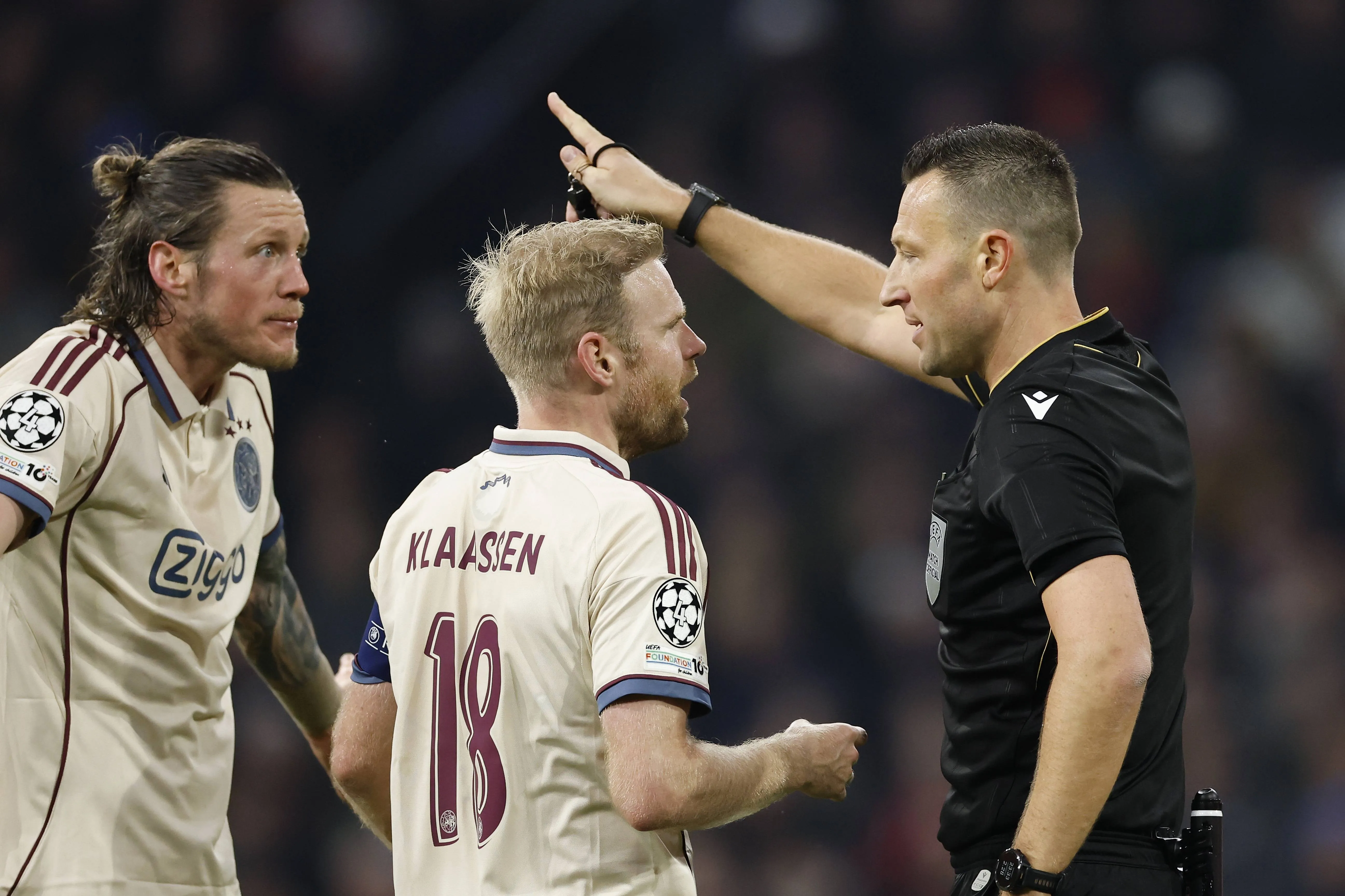 Wout Weghorst, Davy Klaassen, and referee Sven Jablonski during the Champions League match between AFC Ajax and SL Benfica at the Johan Cruijff ArenA on November 25, 2025, in Amsterdam, Netherlands.