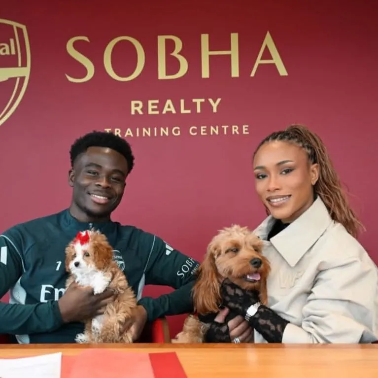 Arsenal forward Bukayo Saka and Tolami Benson pose with their dogs