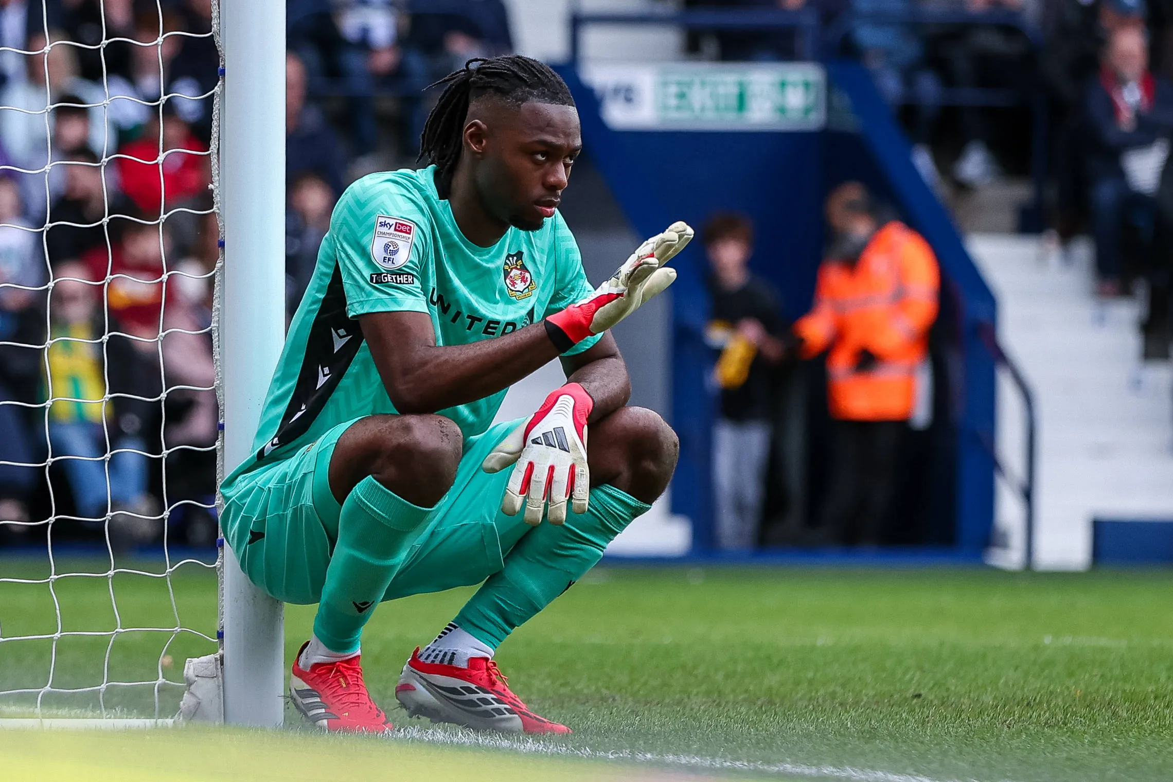 Wrexham AFC's goalkeeper Arthur Okonkwo directs his defense