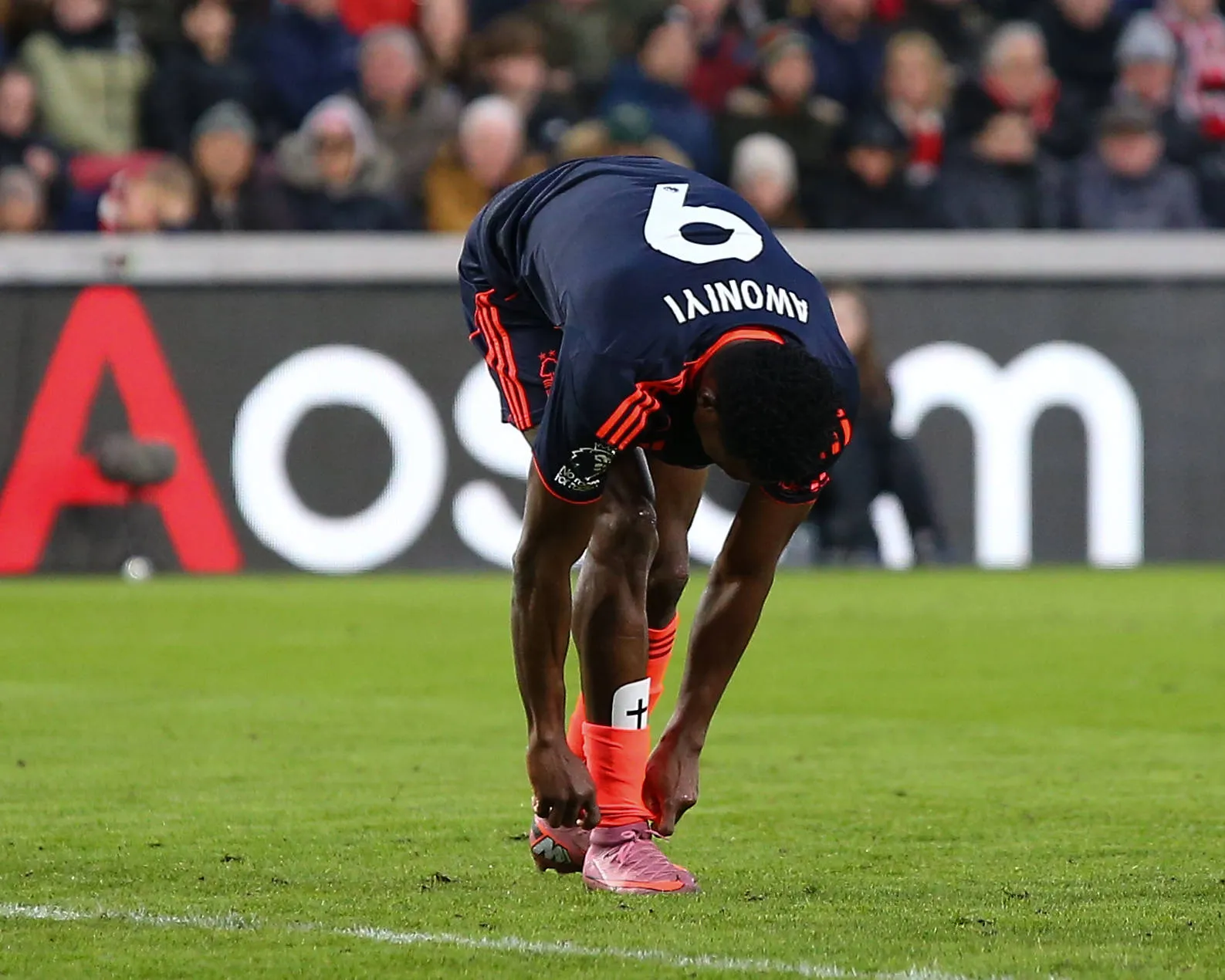 Taiwo Awoniyi takes off shin pad to celebrate goal during the Premier League game between Brentford and Nottingham Forest