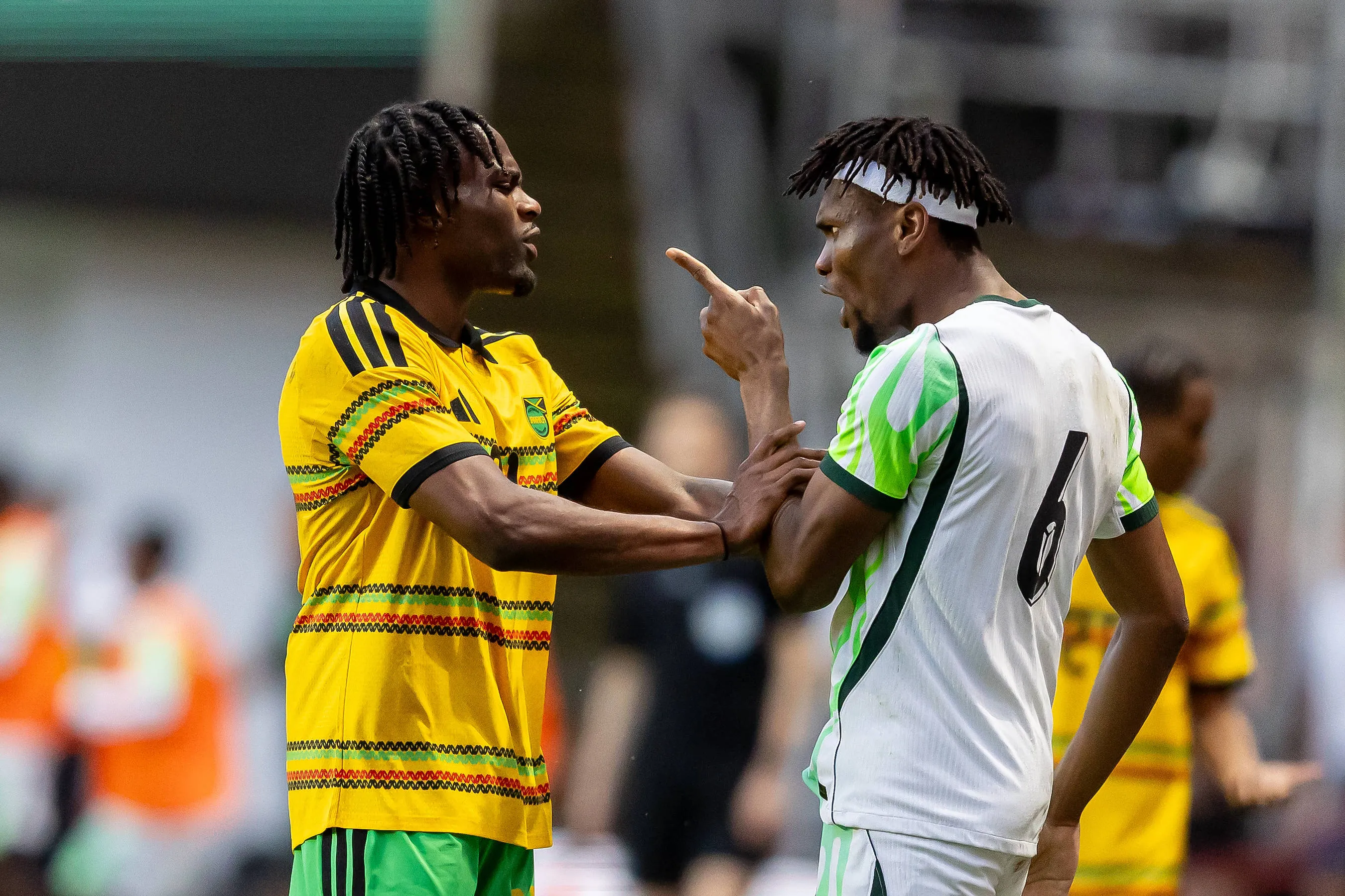 Nigeria defender Chibuike Nwaiwu challenges a Jamaican man, Dajaune Brown 