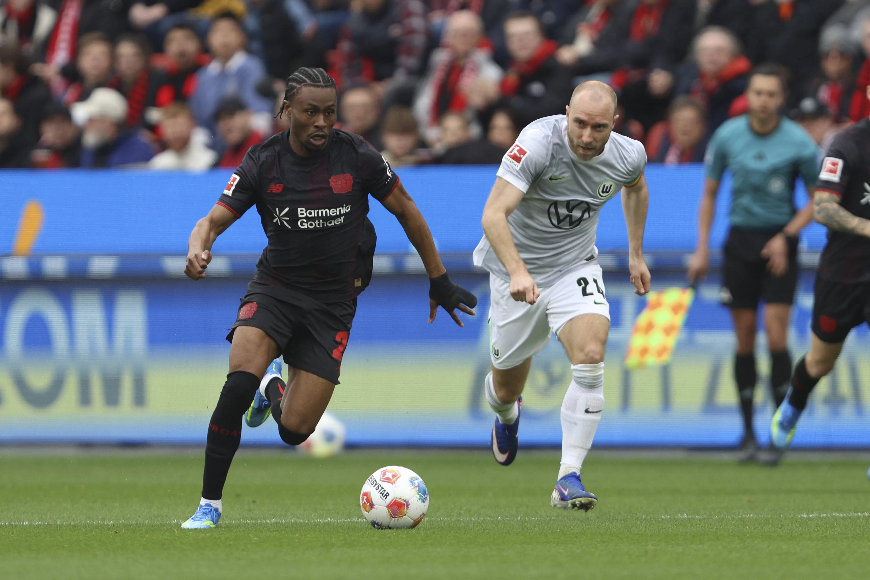 Nathan Tella of Bayern Leverkusen and Christian Eriksen of Wolfsburg