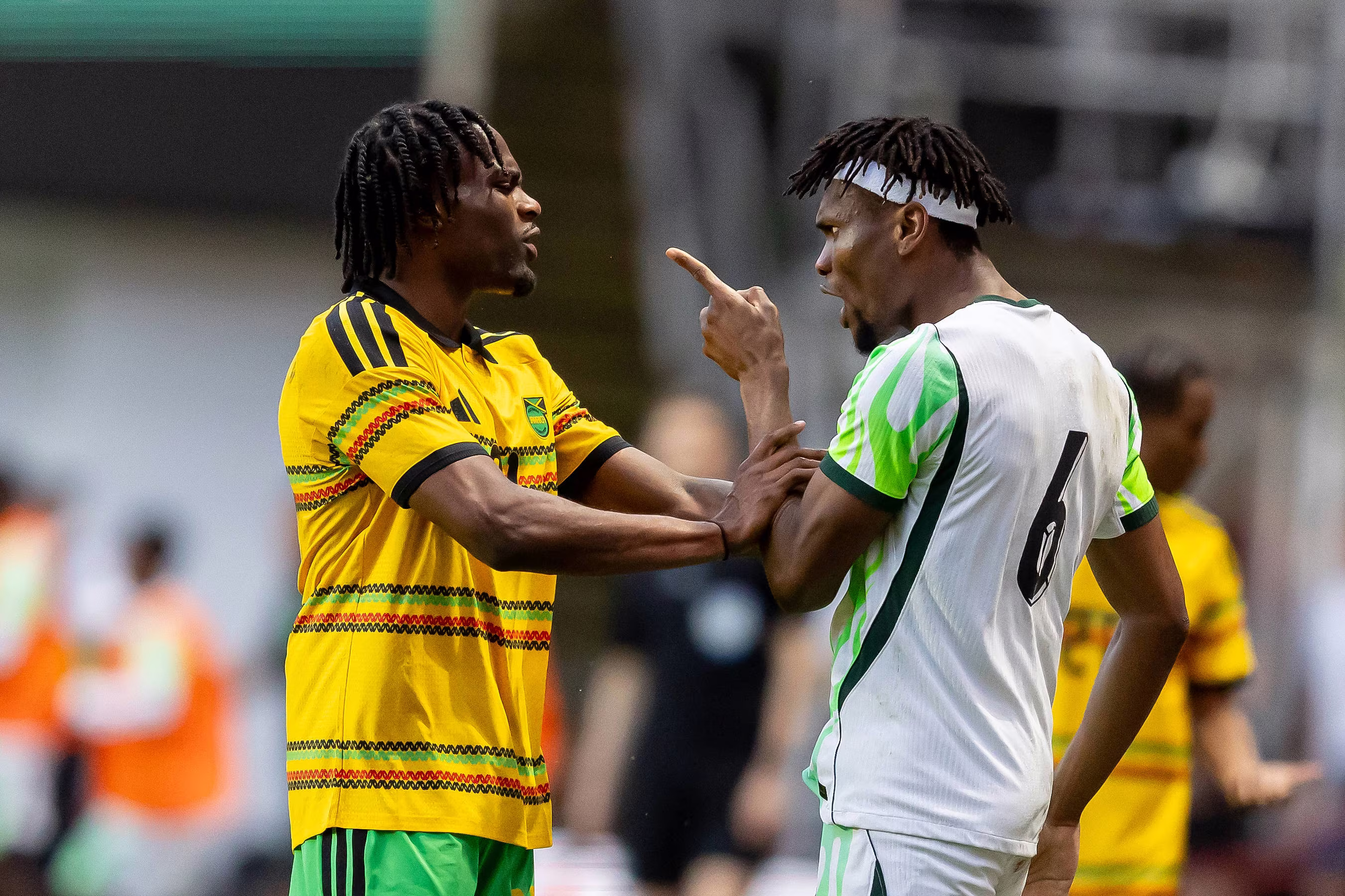 Nigeria defender Chibuike Nwaiwu challenges a Jamaican man, Dajaune Brown