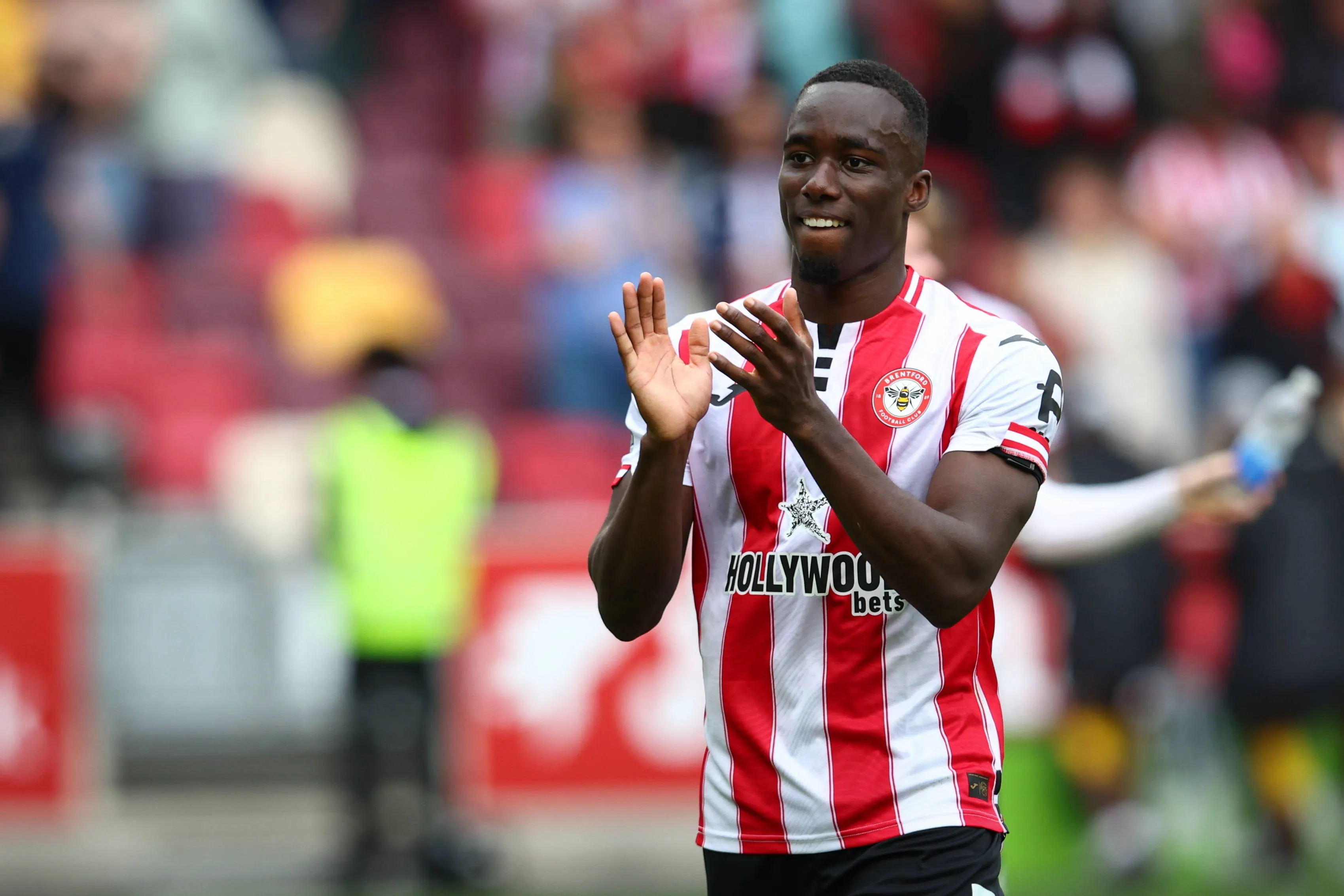 Michael Kayode of Brentford applauds the fans
