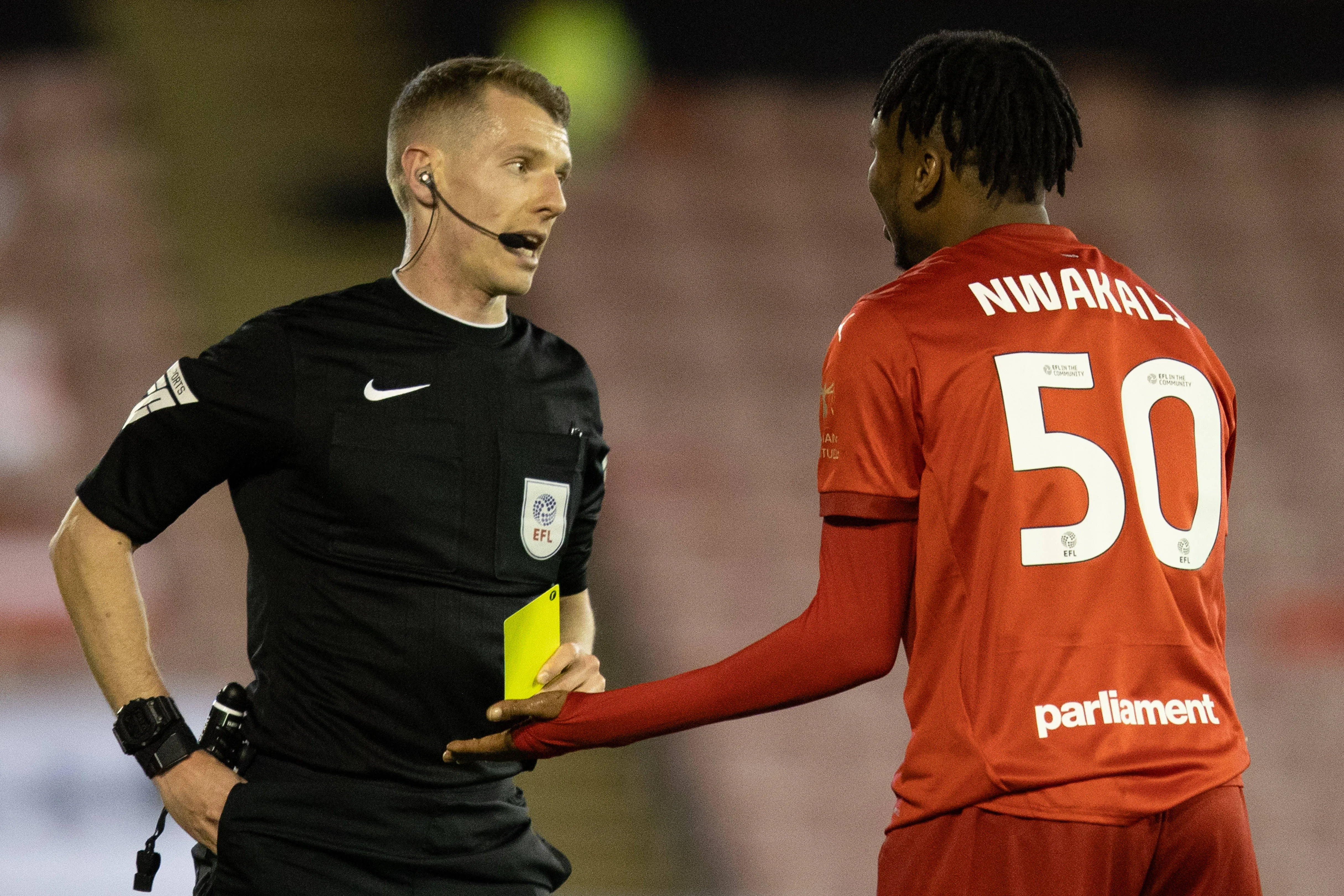 Kelechi Nwakali of Barnsley is shown a yellow card