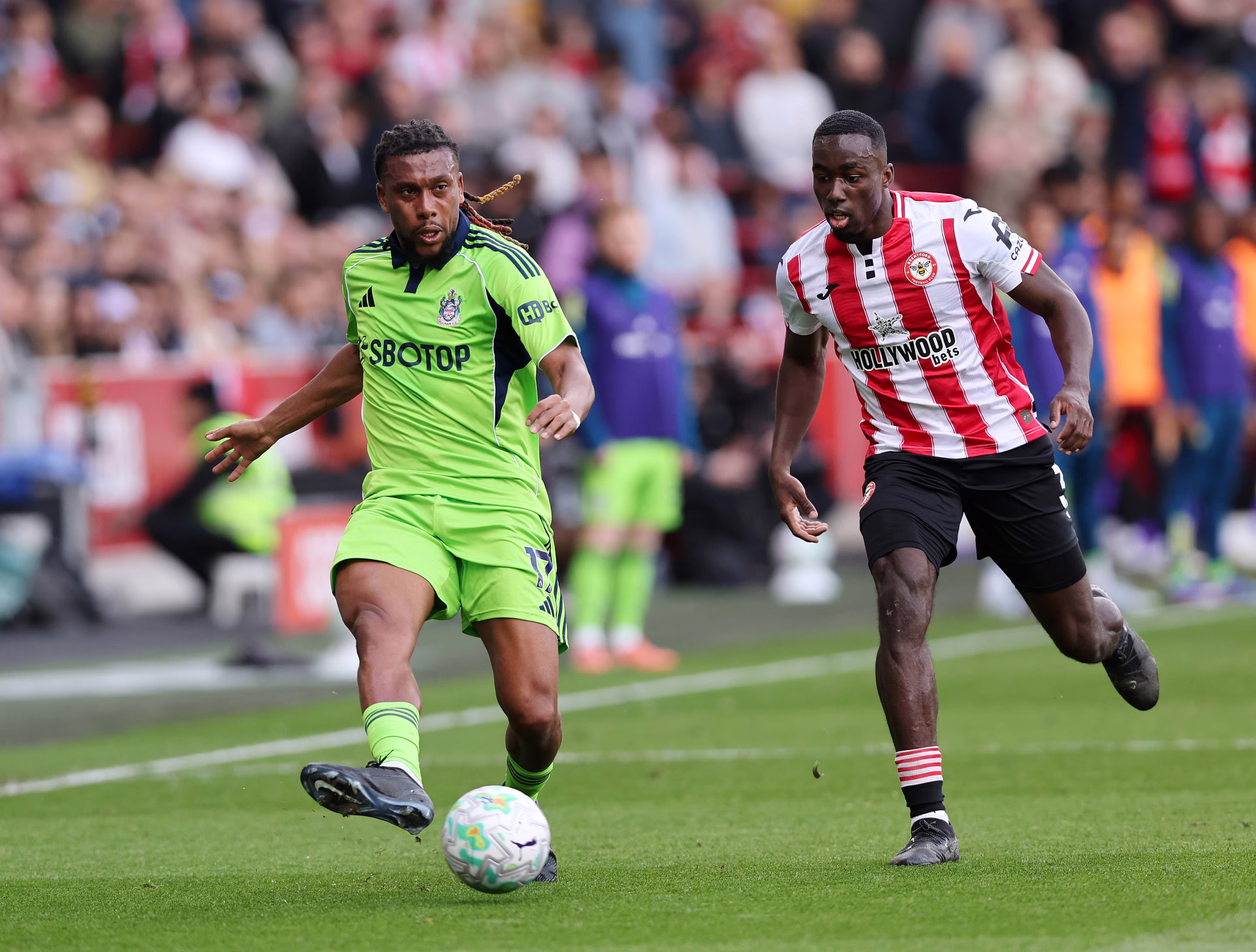  Michael Kayode of Brentford with Alex Iwobi of Fulham