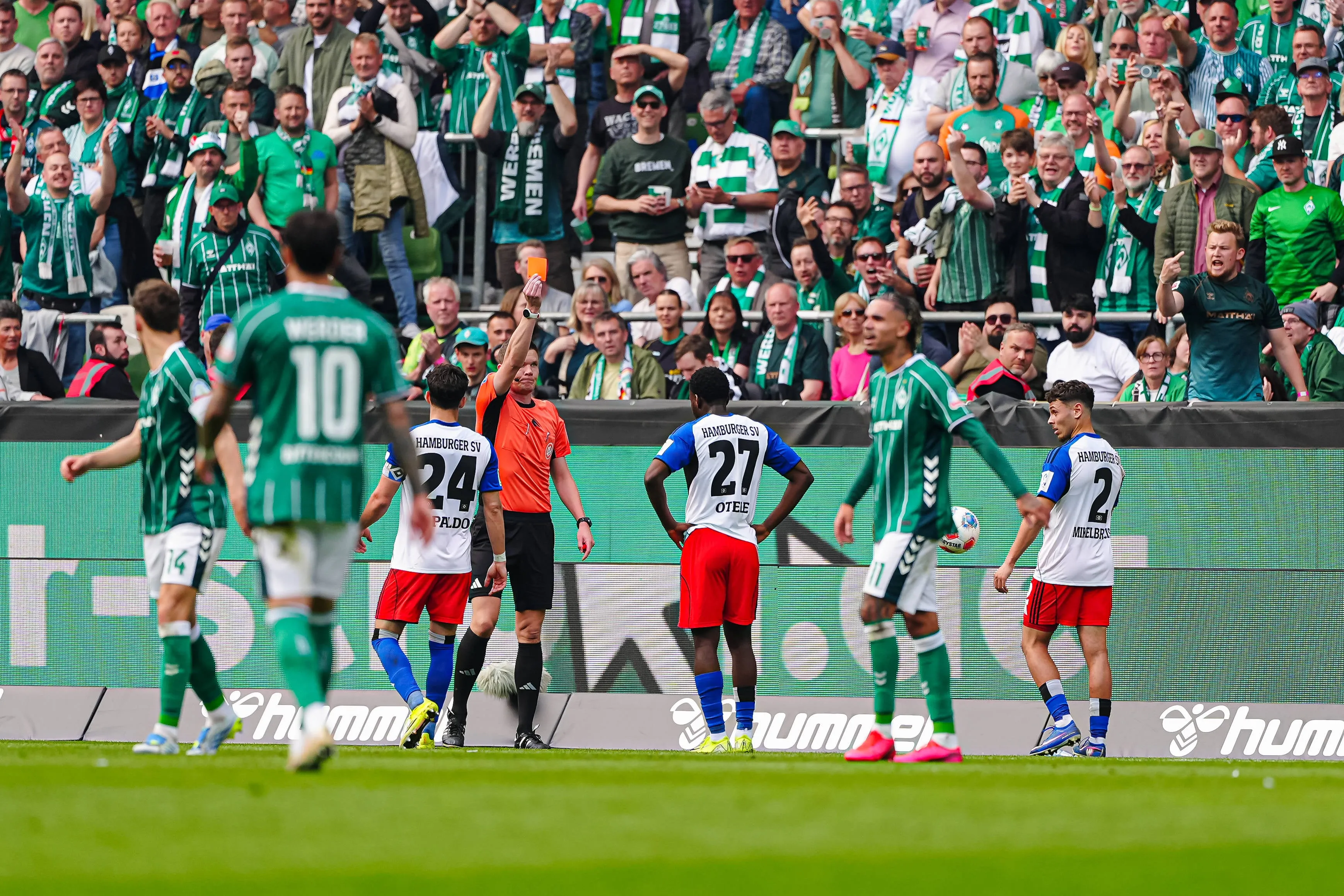 Referee Florian Exner issues a red card for violent misconduct to Philip Otele of Hamburg