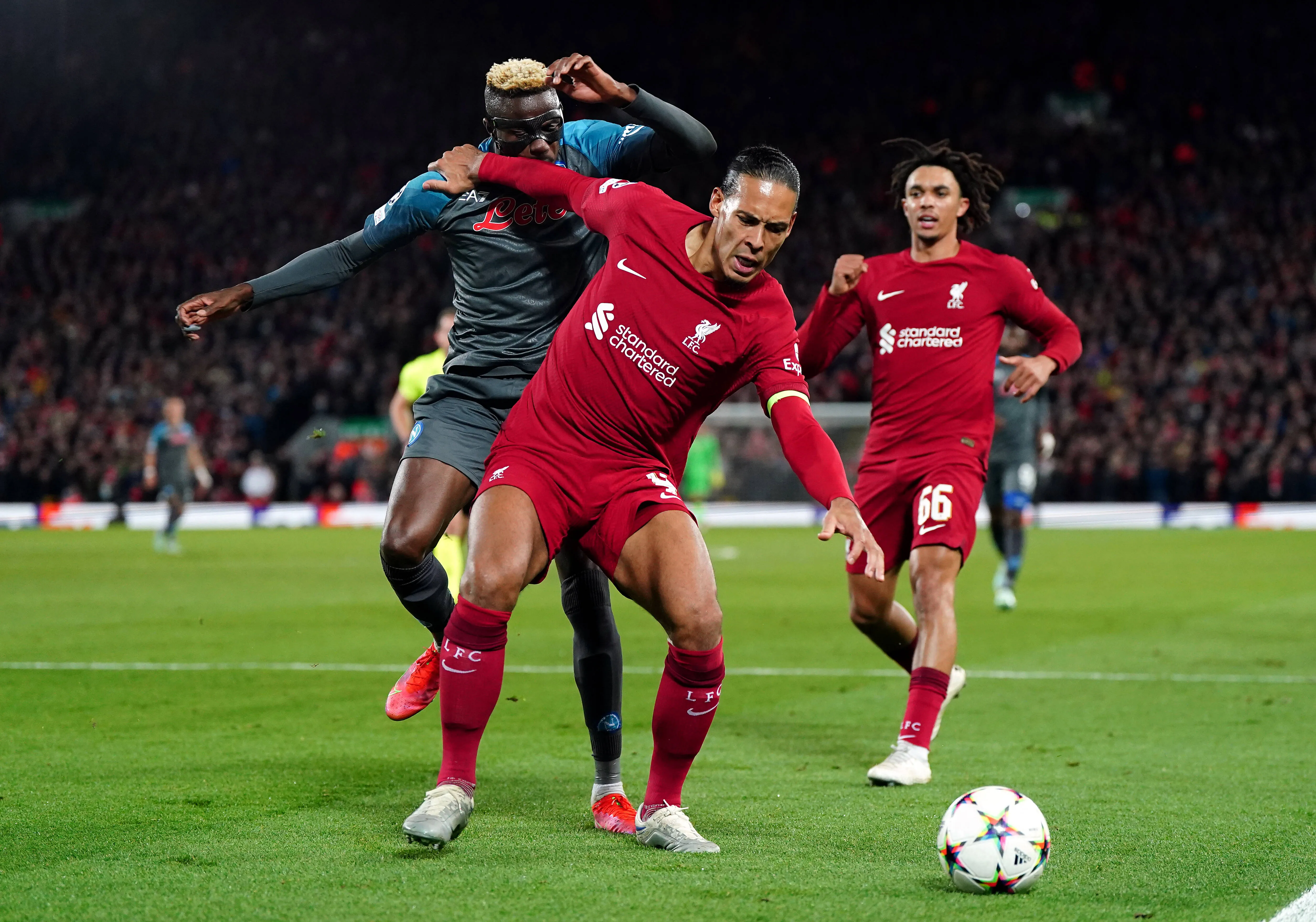 Victor Osimhen is caught in the face by Liverpool's Virgil van Dijk as they battle for the balL
