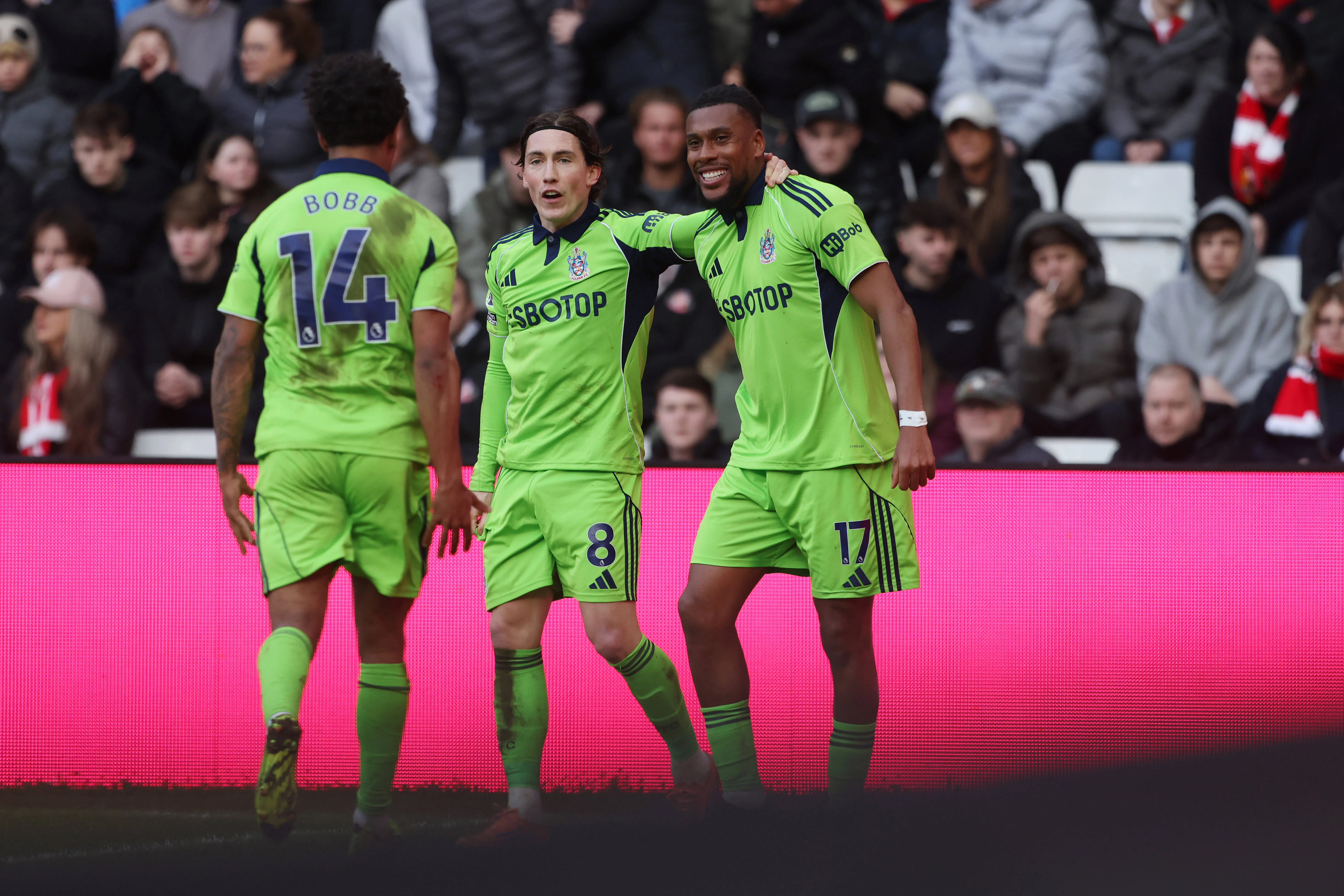 Alex Iwobi of Fulham celebrates with Harry Wilson and Oscar Bobb after scoring their third goal