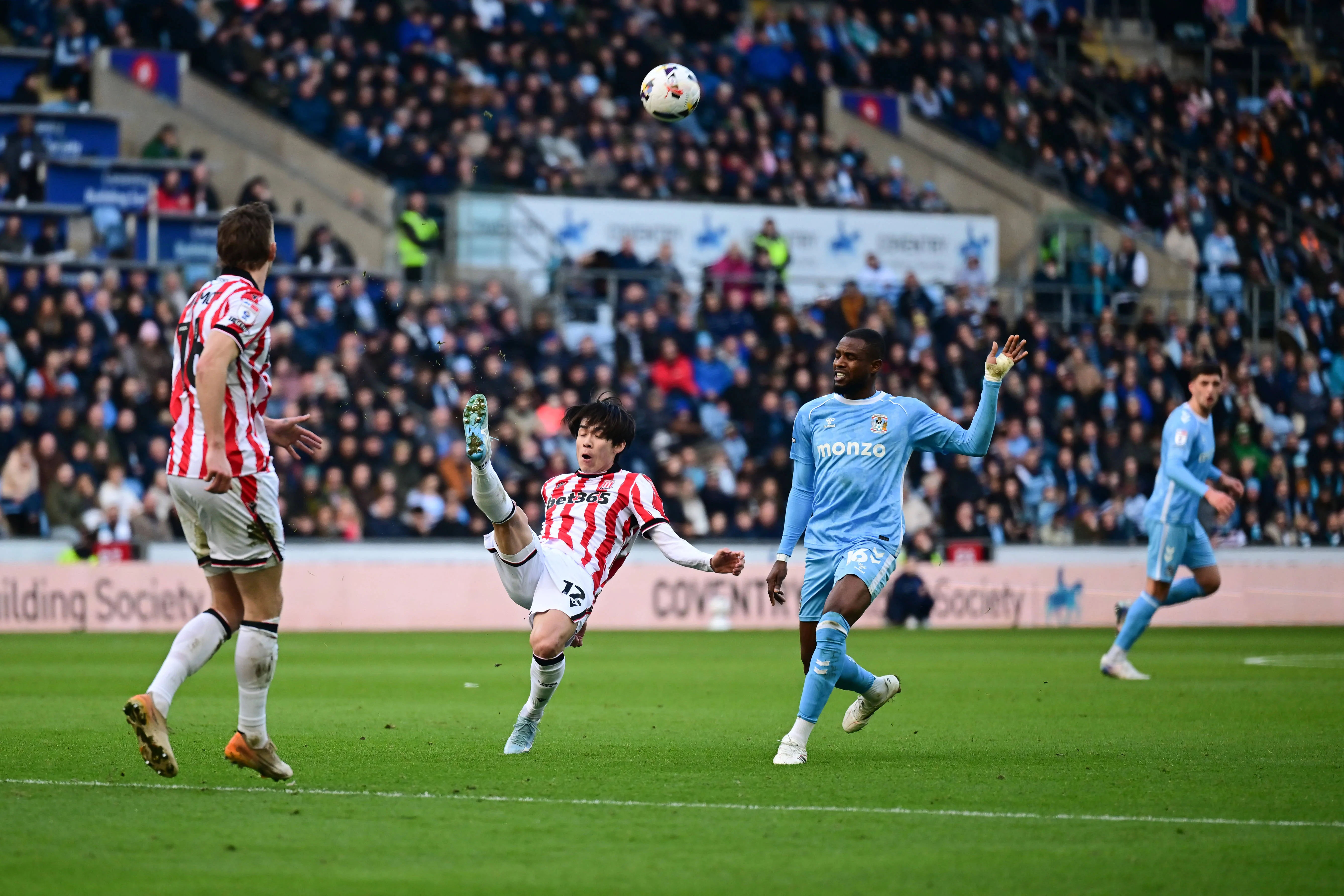 Tatsuki Seko on defensive duties under pressure from Frank Onyeka