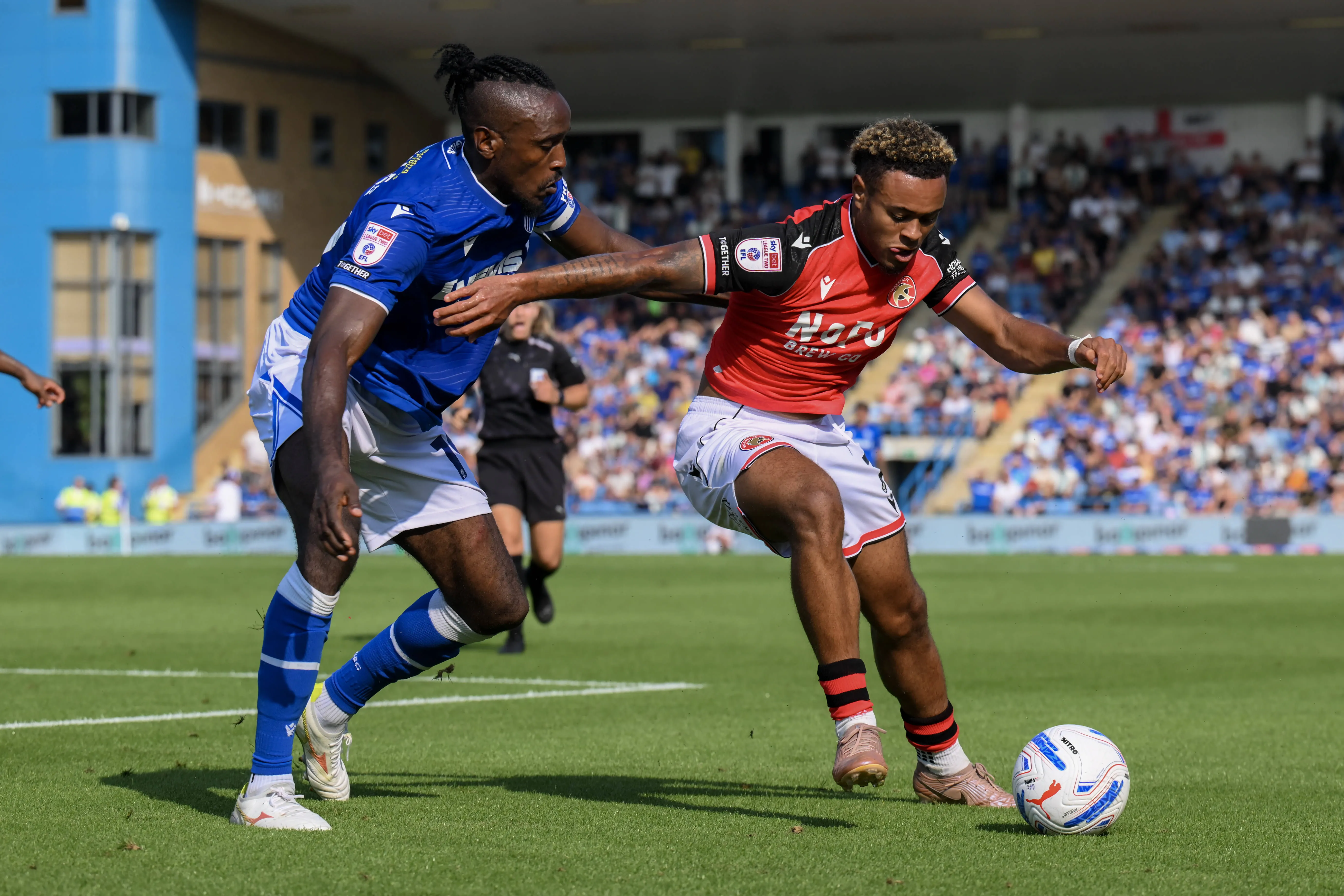 Omar Beckles of Gillingham (R) and Tai Sodje of Walsall (L) battle for the ball 